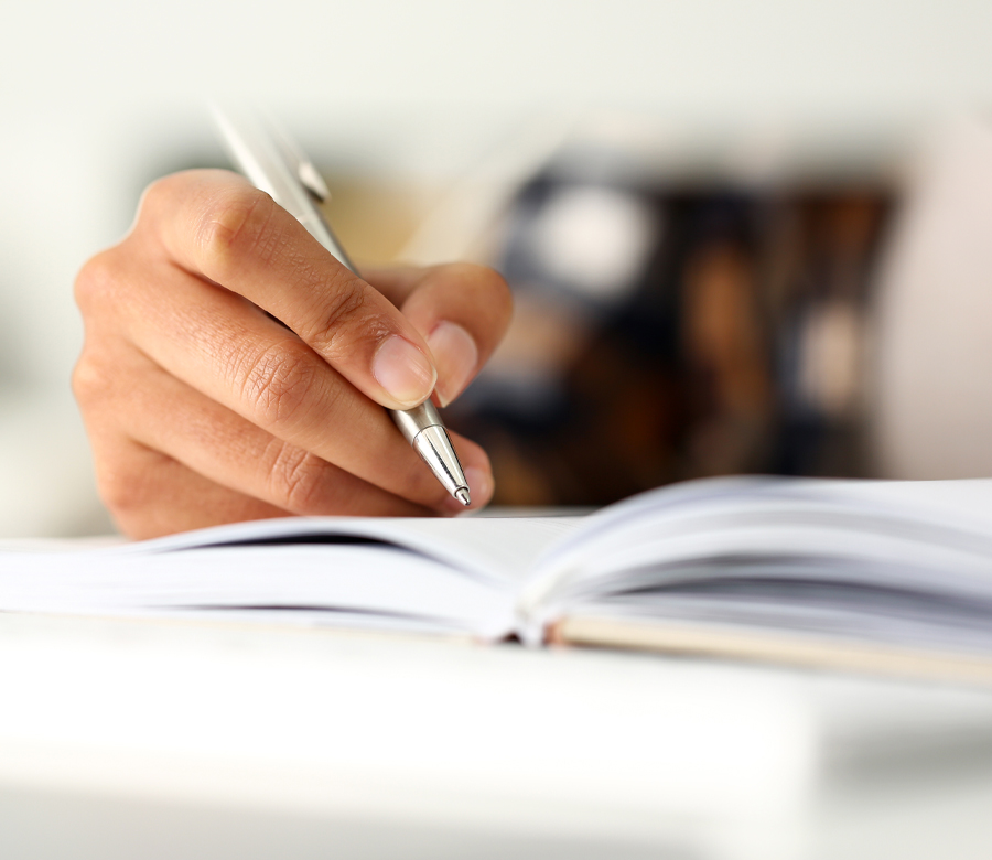 A hand writing in a notebook.