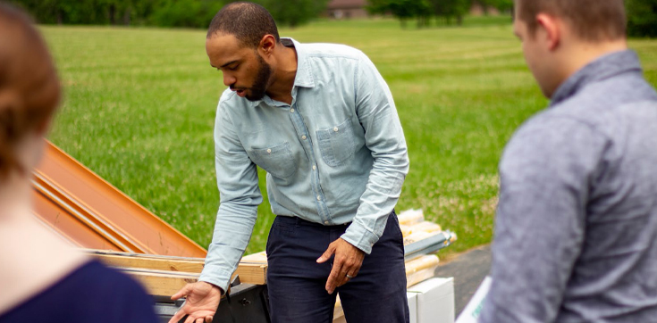 Man outdoors talking to people.